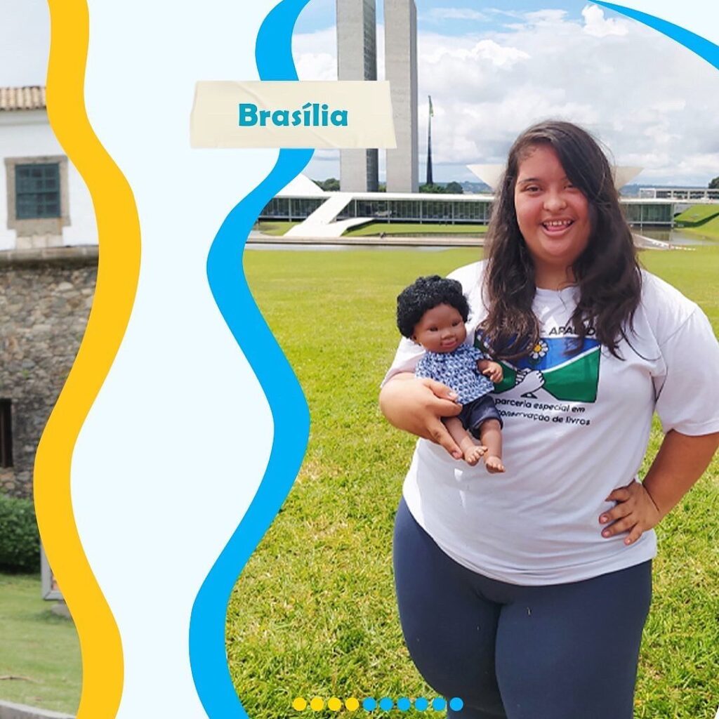 Foto reproduzida do Instagram. Uma moça está segurando a boneca com Síndrome de Down na mão. Ela é de Brasília 