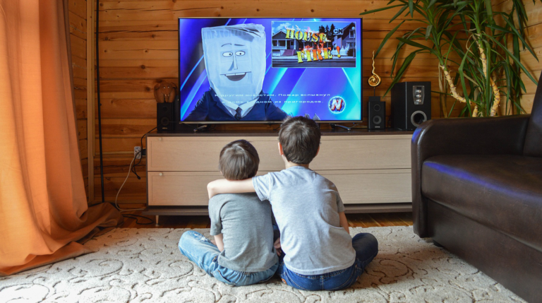 duas crianças assistem televisão