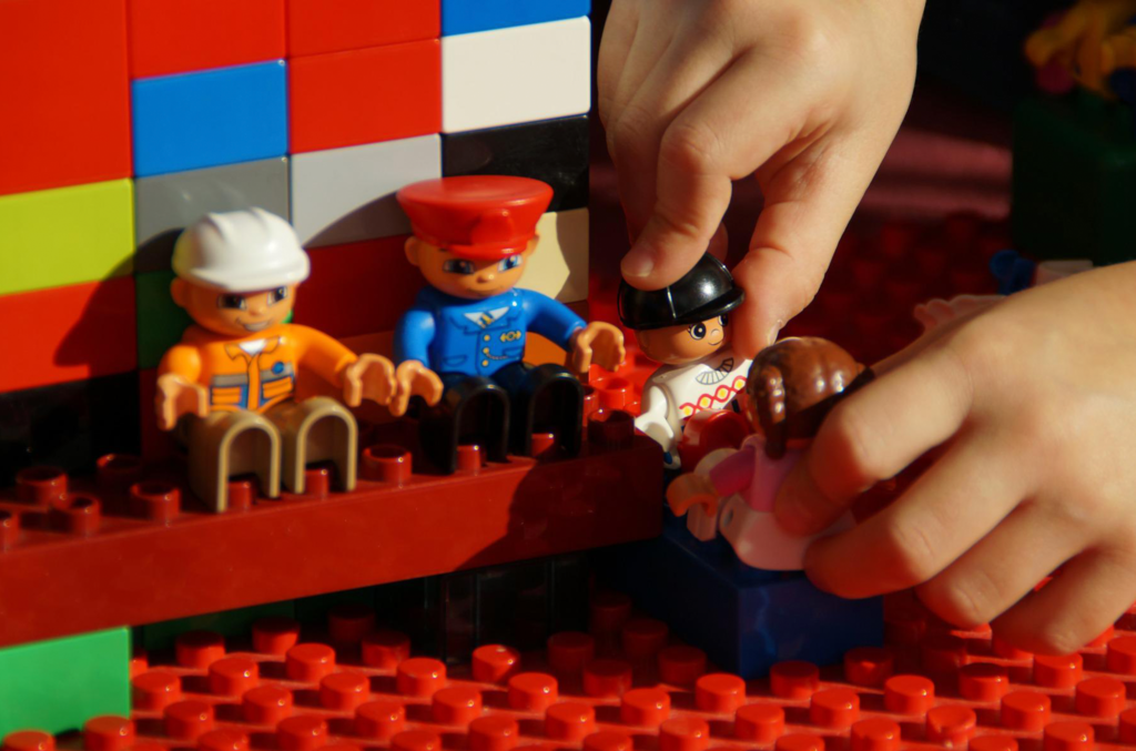 mão de uma criança brincando de lego